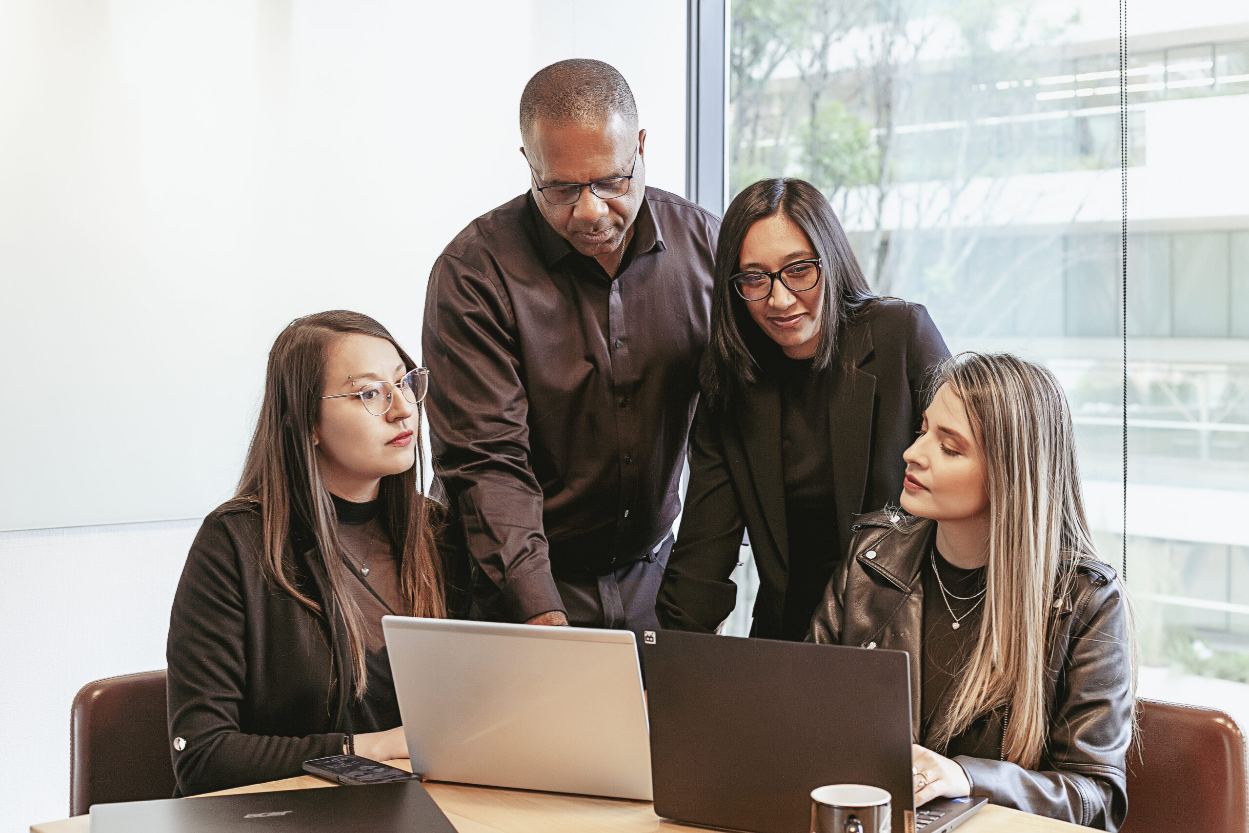 MCM South team members smiling together around two laptops
